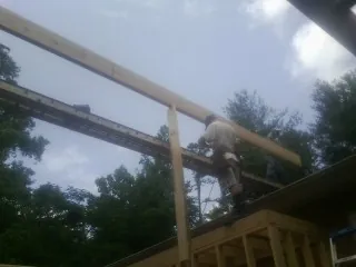 Carpenter setting a ridge beam over a new addition frame — Ice Dam Removal by Roofing Brothers in Kansas City