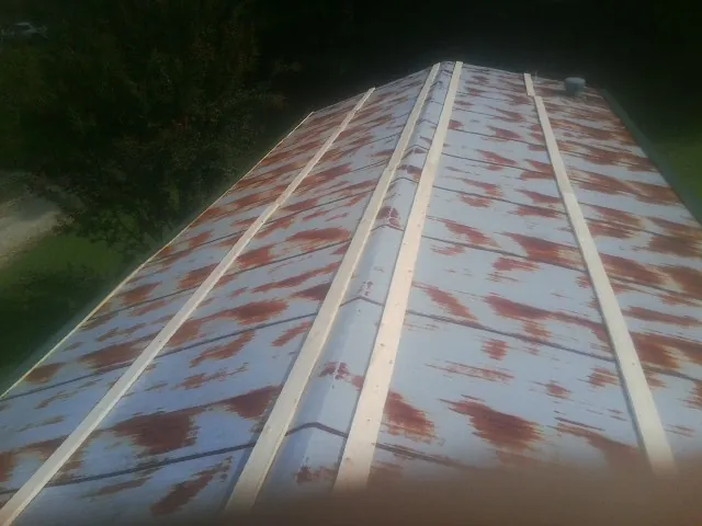 Rusted metal roof panels with new wood purlins before replacement — Storm Damage Roof Repair in Kansas City by Roofing Brothers