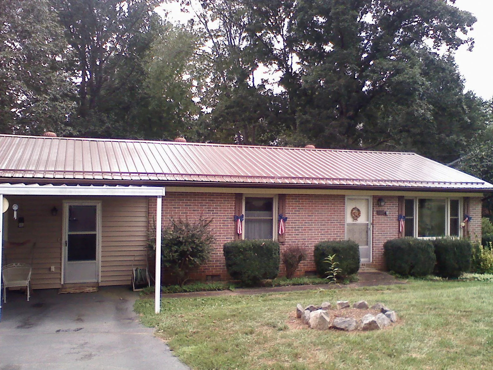 Bronze metal roof and carport on a brick ranch home — Roof Repair work by our crew in Kansas City